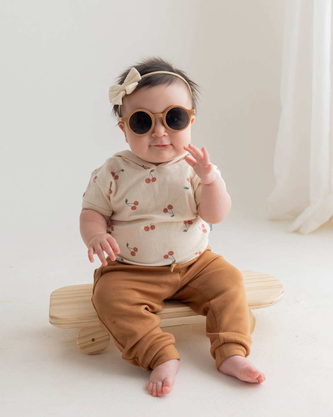 Mãe erguendo o bebê sorridente em ensaio com capim dos pampas